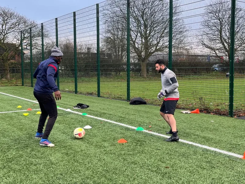 Daryl coaching an adult football fitness session with cones